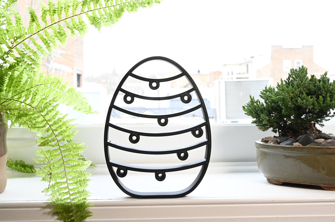 Previous black freestanding Twinkling Lines Easter egg line-art sculpture lifestyle image.