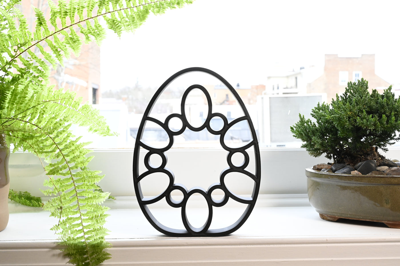 Previous black freestanding Cathedral Lines Easter egg line-art sculpture lifestyle image.