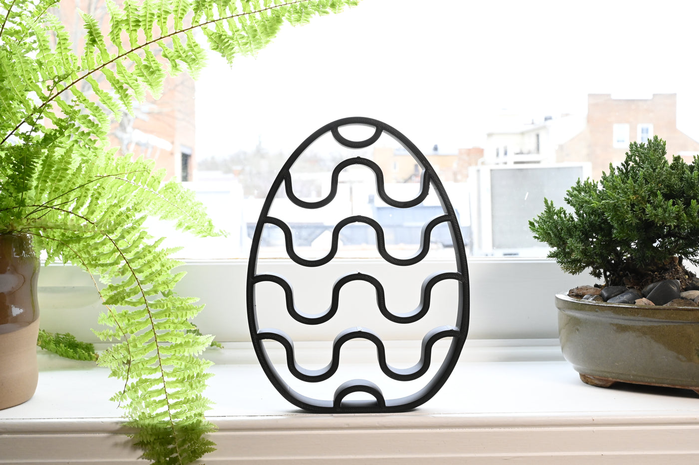 Previous black freestanding Chevron Stripes Easter egg line-art sculpture lifestyle image.