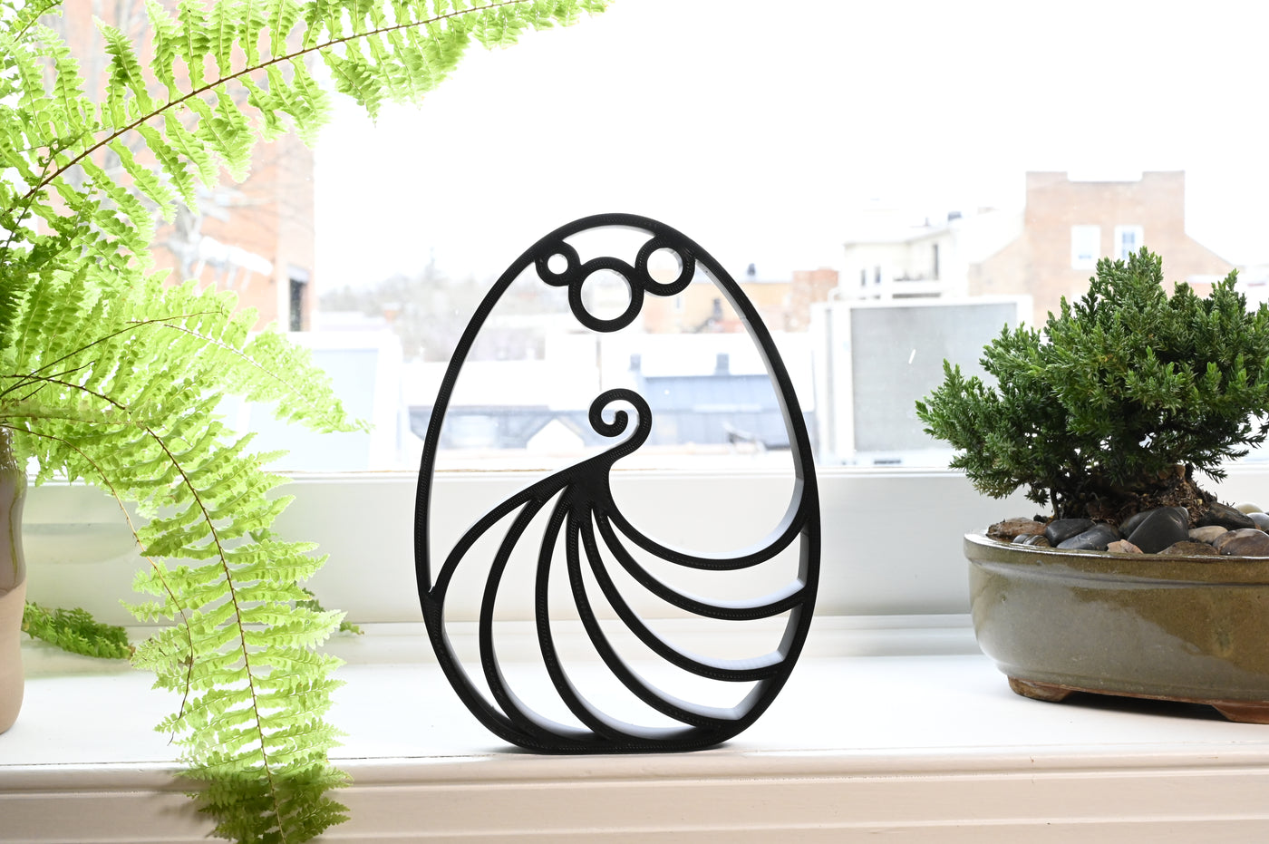 Previous black freestanding Elegant Twirl Easter egg line-art sculpture lifestyle image.