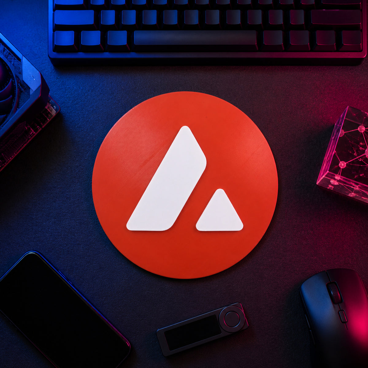 Red circular Avalanche crypto logo sign displayed flat on a neon-lit trader desk beside a keyboard, hardware wallet, and technical equipment.