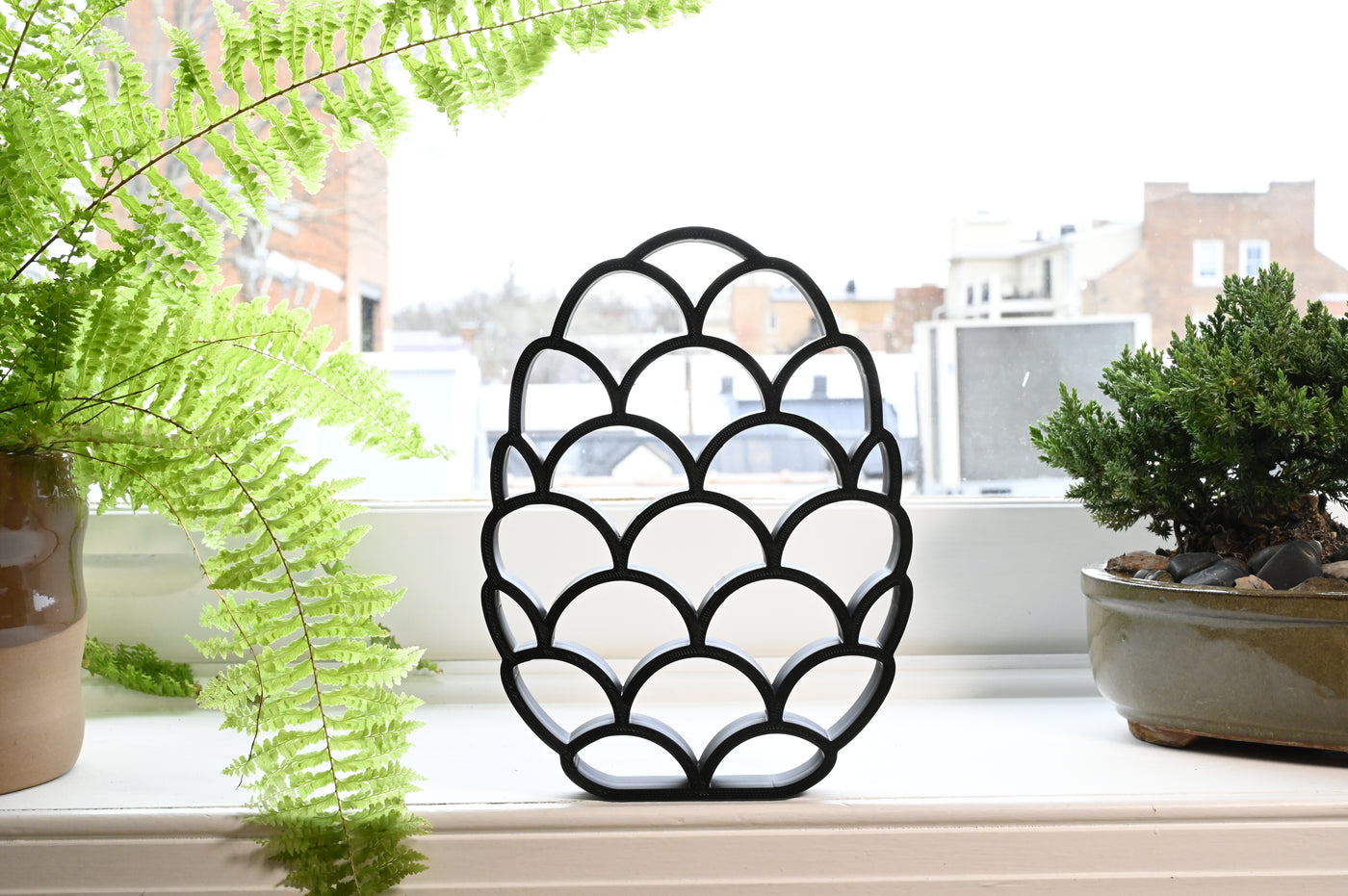 Previous black freestanding Dragon Scales Easter egg line-art sculpture lifestyle image.
