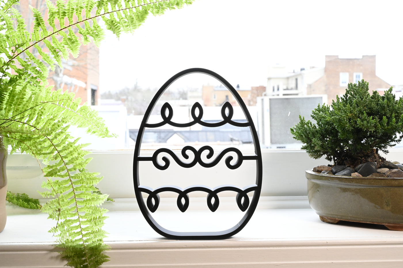 Previous black freestanding Squiggly Wave Easter egg line-art sculpture lifestyle image.