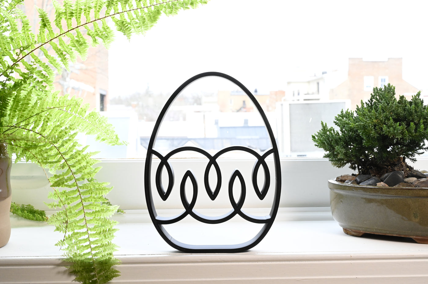 Previous black freestanding Ribbon Drift Easter egg line-art sculpture lifestyle image.