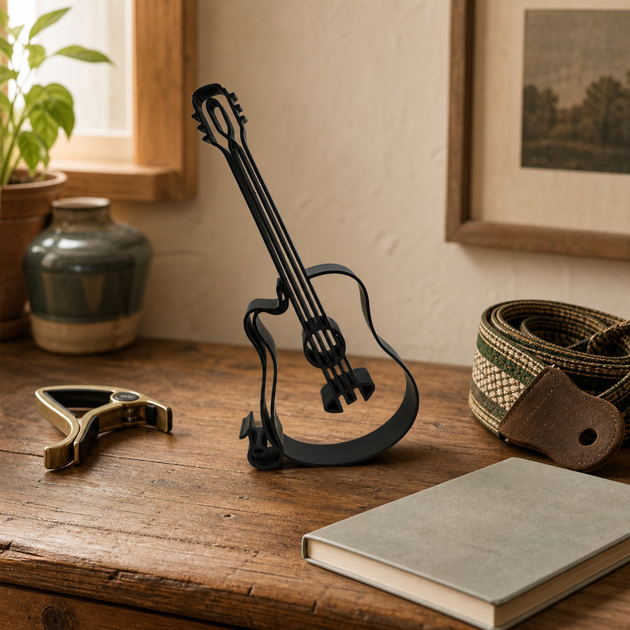 Acoustic guitar line-art sculpture displayed on a wooden table